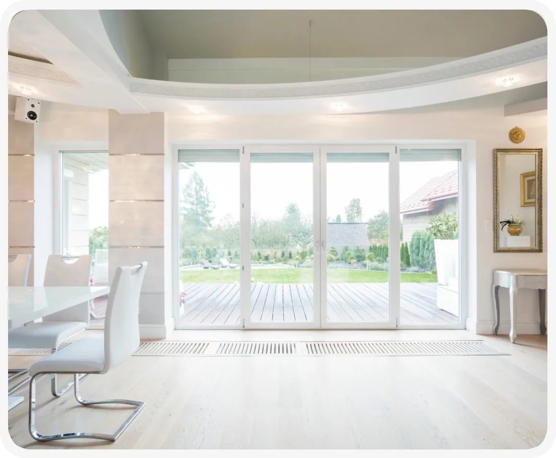 A large room with sliding glass doors and white furniture.