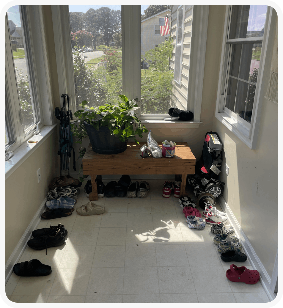A room with many pairs of shoes on the floor.